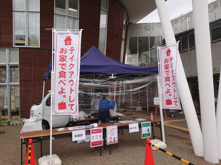 「テイクアウトしてお家で食べよ。」ののぼりが立つ、屋外に設けた飲食店弁当のドライブスルー販売ブース。